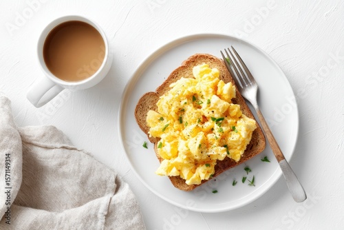 Fluffy scrambled eggs on toast, accompanied by coffee and cozy n