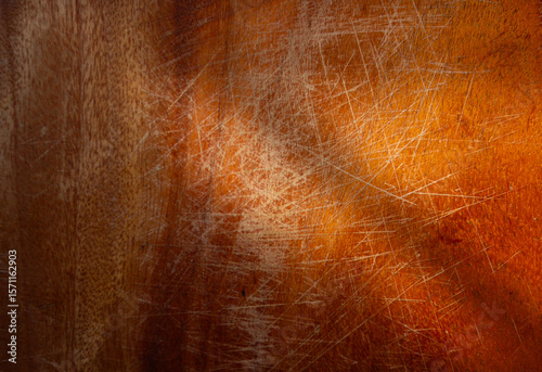 Texture of an old, reddish-brown wooden surface with many scratches. A rustic, warm background showing the patina of time and use
