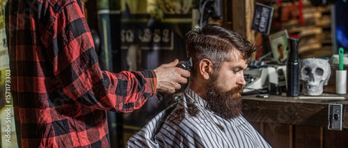 Man client getting haircut. Hipster barbershop. Hands of barber with hair clipper. Barber with clipper trimming hair
