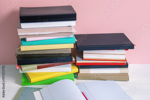 Two stacks of colorful books on white rustic tables. Back to school concept. Copy space
