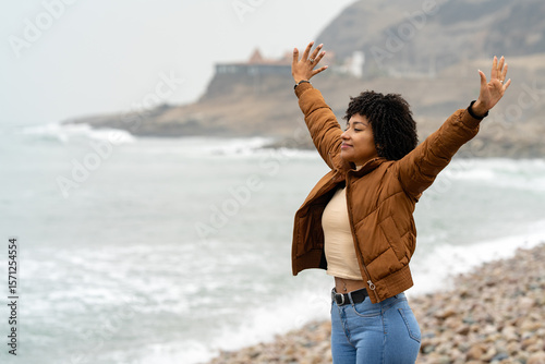 Young woman enjoying freedom on the beach with open arms