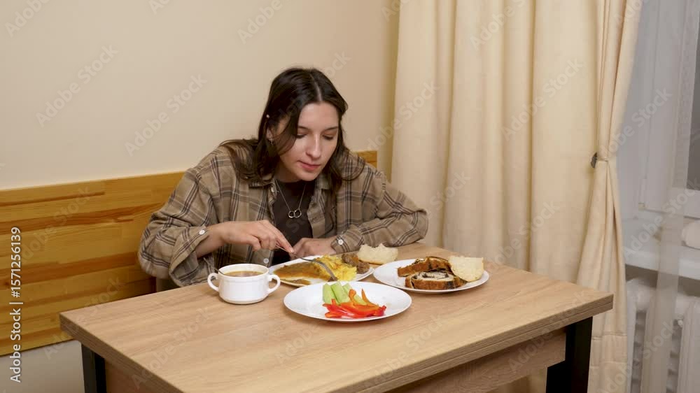 A beautiful girl is sitting at a table, eating and drinking. A beautiful girl is sitting at a table, eating and drinking.