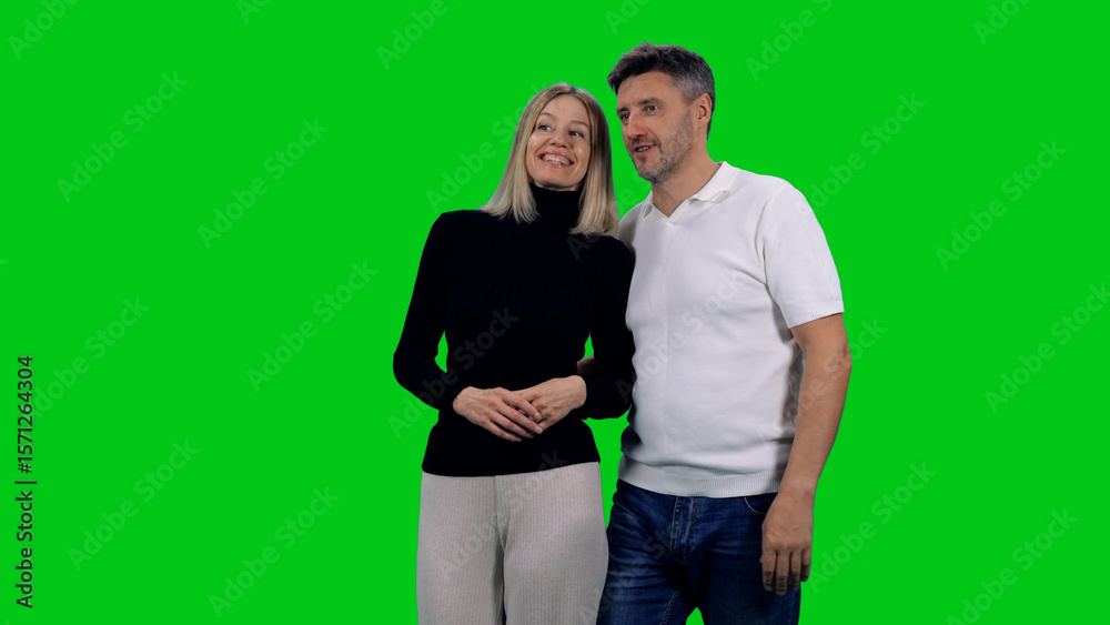 Fototapeta premium Beautiful laughing mid adult loving couple on green chroma key background