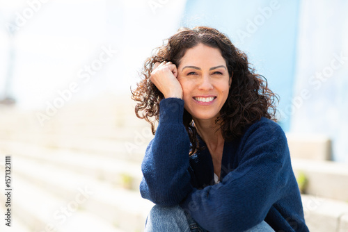 Portrait of relaxed, smiling middle age woman sitting outdoors