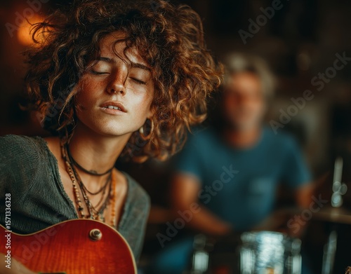 Close-up of a young woman playing a red electric guitar, in the club.