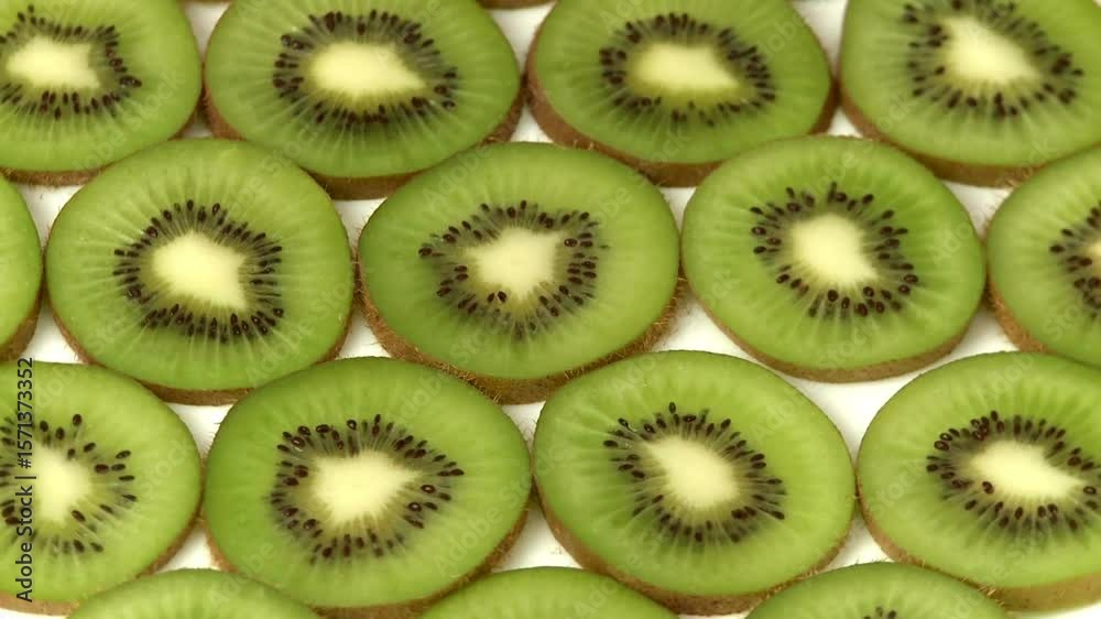 Kiwi fruit slices on a fresh green background