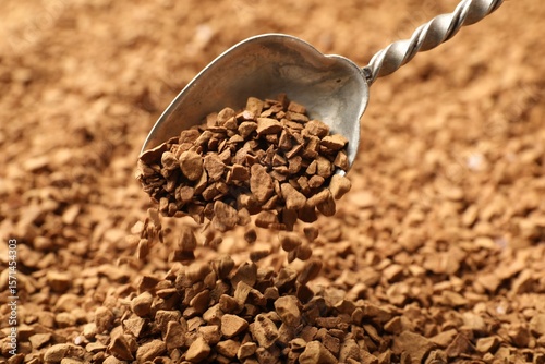 Spoon with aromatic instant coffee as background, closeup
