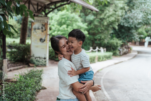 Canvas Print Happy Asian mother and son sharing a joyful laugh during a walk in a tropical zoo