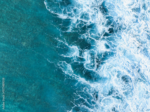 Aerial view of the mesmerizing turquoise sea meeting the foamy white waves, creating a stunning contrast of colors and textures, Surfspot Cokes, Thulusdhoo, Kaafu Atoll, Maldives.