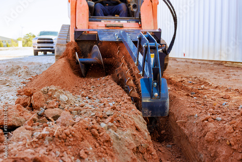 Konstfotografi Worker operates trencher to dig trench in ground for construction purposes