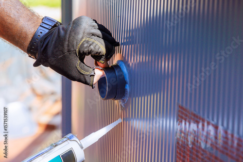 Worker applies sealant filtration system to swimming pool while wearing gloves during construction work.