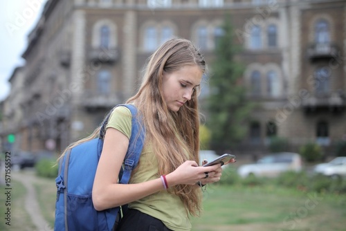 young woman uses a smartphone in the street