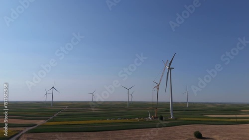 Wind turbine installation using a large construction crane. The assembly process of the turbine tower and rotor blades. Aerial view	