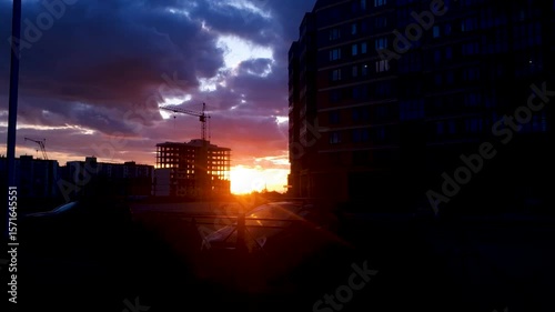 Sunset in the evening at dusk. Rays of setting orange bright sun in urban environment in the evening.