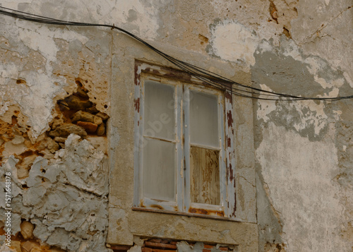 abandoned building with broken window and exposed wall