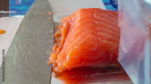 A piece of red fish and a knife next to it. Close-up of a piece of salmon