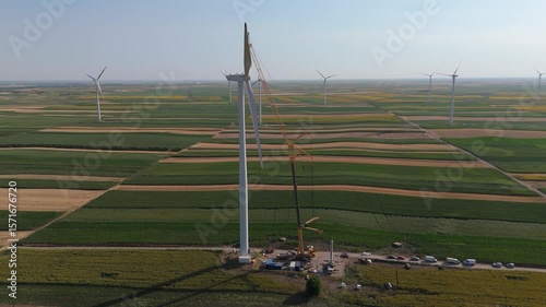 Wind turbine installation using a large construction crane. The assembly process of the turbine tower and rotor blades. Aerial view	