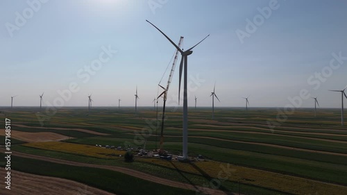 Wind turbine installation using a large construction crane. The assembly process of the turbine tower and rotor blades. Aerial view	