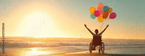 The person in a wheelchair enjoying the sunset with colorful balloons.