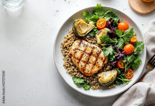 A healthy diet meal featuring steamed artichoke hearts served with grilled chicken breast, quinoa, and fresh greens, arranged on a white ceramic plate