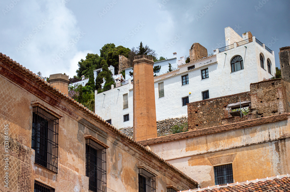 A peaceful walk through the charming narrow streets, surrounded by whitewashed houses and colorful flowers in Frigiliana, Spain A peaceful walk through the charming narrow streets, surrounded by whitewashed houses and colorful flowers in Frigiliana, Spain