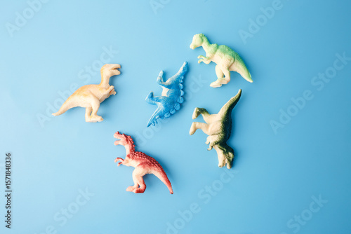 Colorful dinosaur figurines on blue background for toy catalog, kids education, preschool visuals, creative play, museum content, blog illustrations, branding for toy packaging or science kits,
