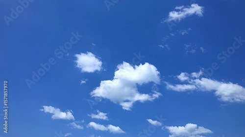 Timelapse video of blue sky with drifting white clouds, peaceful nature scene with calm motion and clear atmosphere