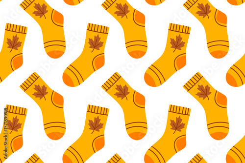 Seamless pattern with orange socks decorated with autumn leaves. Cozy fall-themed design for seasonal projects.