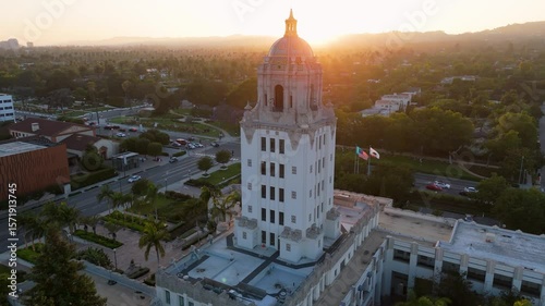 Golden hour drone orbit around Beverly Hills City Hall with sunset skyline