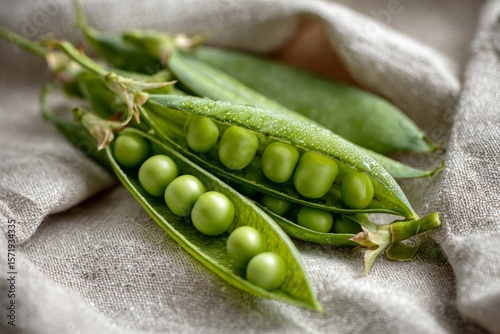 Close-up of fresh green peas in pod on textile background