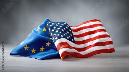 Supply chain and import tariff, Two intertwined flags of the European Union and the United States on a wooden surface with a blurred gray background.