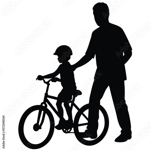 Father gently supports his son riding a bicycle with training wheels in this silhouette