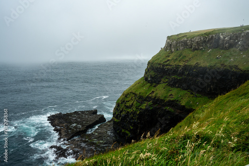Bild auf Leinwand Windy coastal cliffs and green valleys meet the North Atlantic on Faroe Islands’