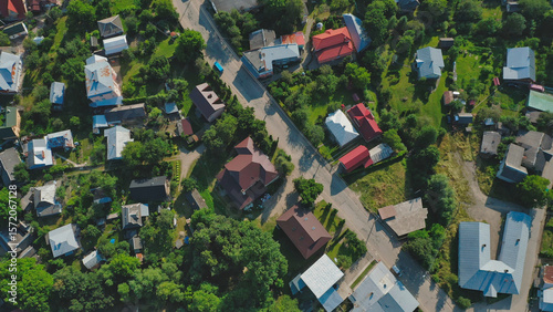 Top view of a vibrant village showcasing houses and green landscapes under bright sunlight