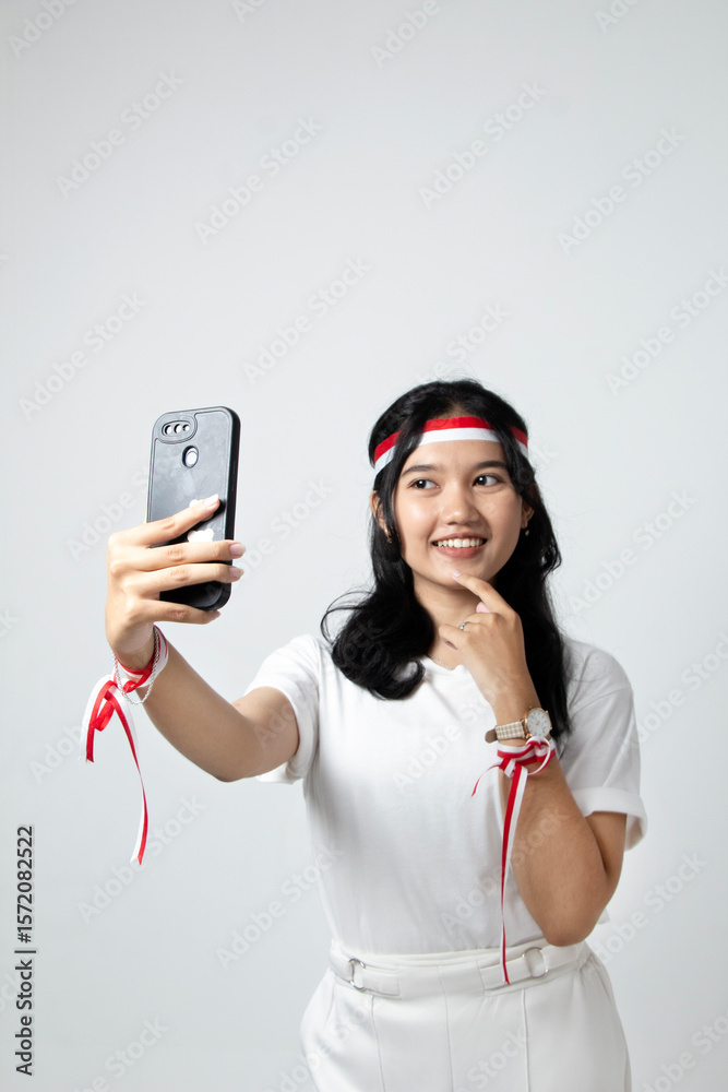 Naklejka premium Portrait of an Indonesian girl with loose hair taking a selfie, Indonesian Independence Day theme wearing a white t-shirt