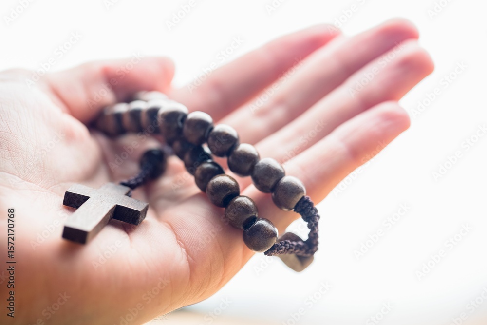Naklejka premium Hand holding rosary beads