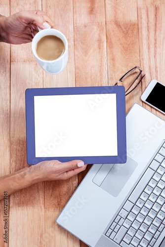 Overhead of feminine hand using tablet