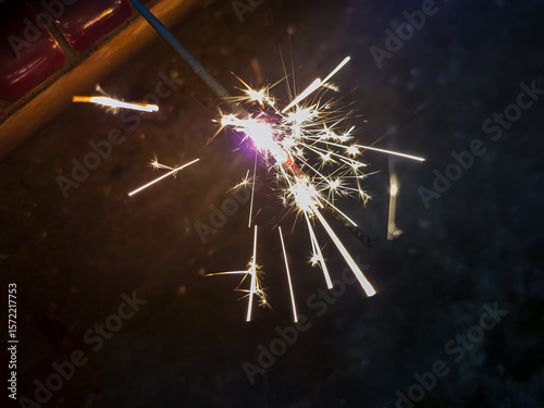 Burning sparkler on a black background wallpaper.
