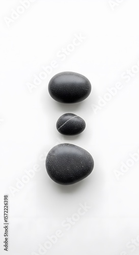 Three Smooth Black Zen Stones Aligned Vertically on a Clean White Background, Representing Balance, Serenity, and Minimalist Elegance