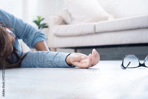 Woman fainting and collapsing on the floor, possibly caused by low blood pressure, heart problems, heat exhaustion, low blood sugar (hypoglycemia) or emotional stress