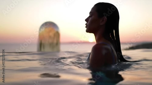 Serene Sunset Silhouette: Woman Relaxing in Infinity Pool