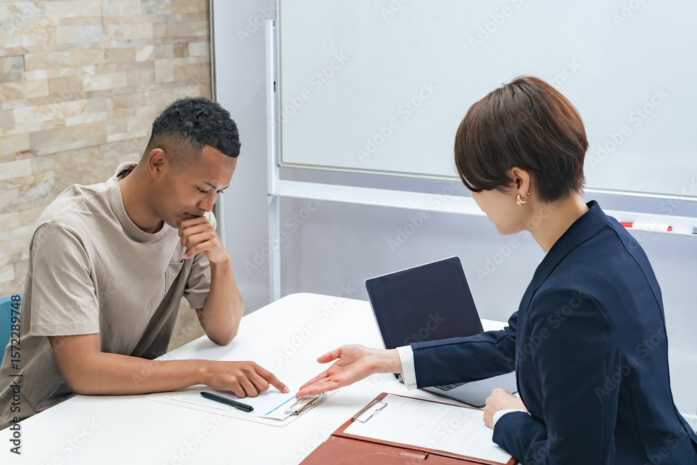 面談する黒人男性と日本人女性スタッフ 面談する黒人男性と日本人女性スタッフ