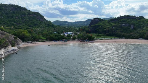 Empty beach between mountains and open green sea