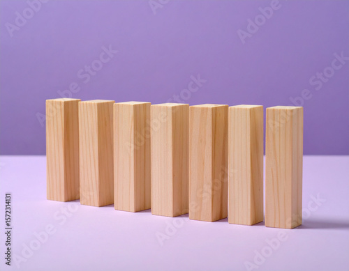 A neat row of identical natural wooden blocks stands upright on a vibrant purple background, symbolizing uniformity, stability, potential, or the foundational building blocks of progress and equality.