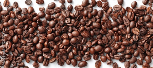 Roasted coffee beans scattered on a white surface (1)