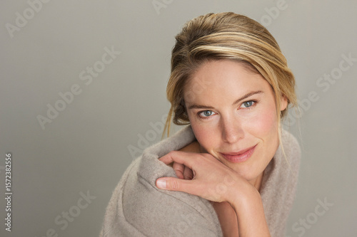 Studio portrait of beautiful blond woman against gray background
