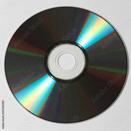 A shiny compact disc with iridescent reflections, catching the light,