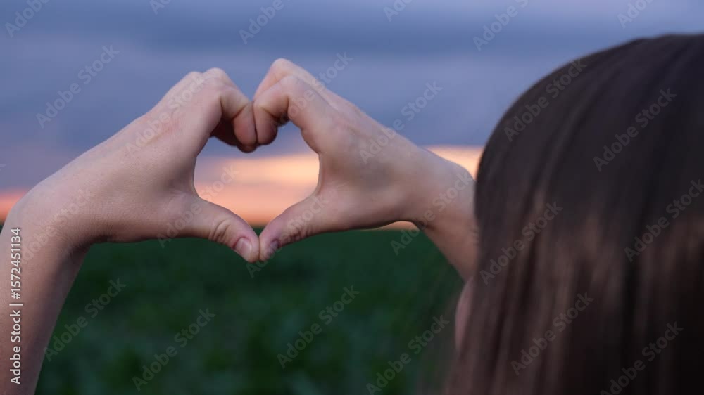 Woman in checkered shirt outdoors, Heart hands at golden hour, Support for agriculture movement, Country girl at sunset, Positive field vibes, Happy working in nature, Soft sunset over green plants Woman in checkered shirt outdoors, Heart hands at golden hour, Support for agriculture movement, Country girl at sunset, Positive field vibes, Happy working in nature, Soft sunset over green plants