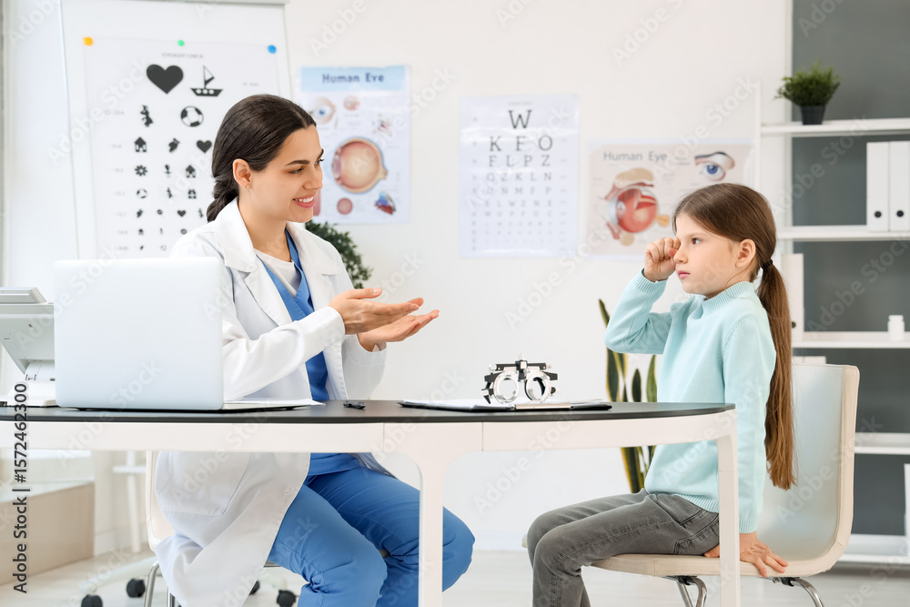 Obraz premium Female ophthalmologist working with little girl at table in clinic