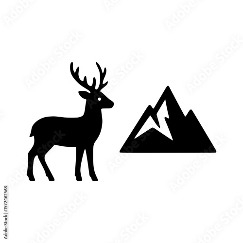 Black silhouette of a deer standing next to jagged mountains